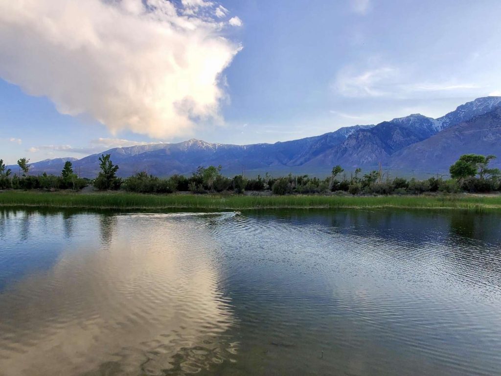 White clouds above the mountains reflecting on Lake olancha